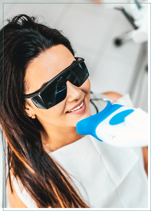 Woman getting professional teeth whitening in dental office