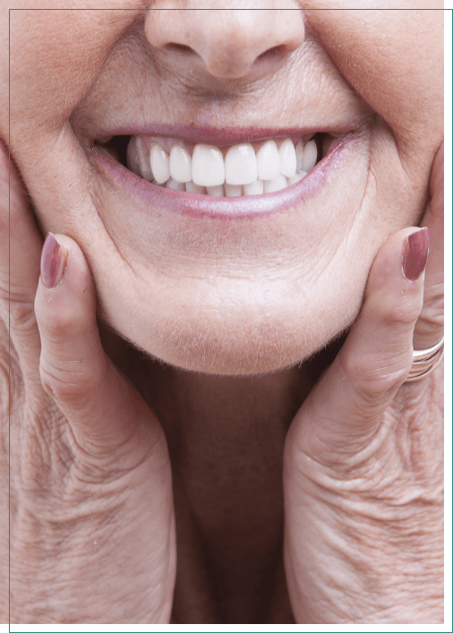 Smiling senior woman touching her face