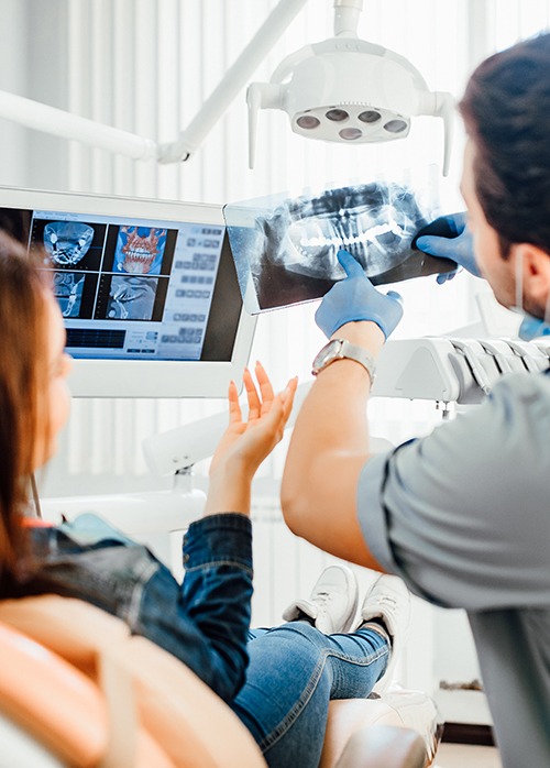 a dentist showing a patient her X-rays