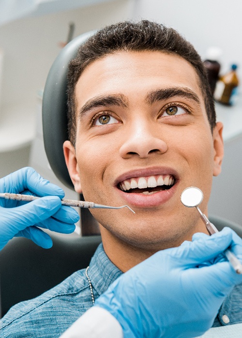 a dental hygienist examining a patient’s teeth