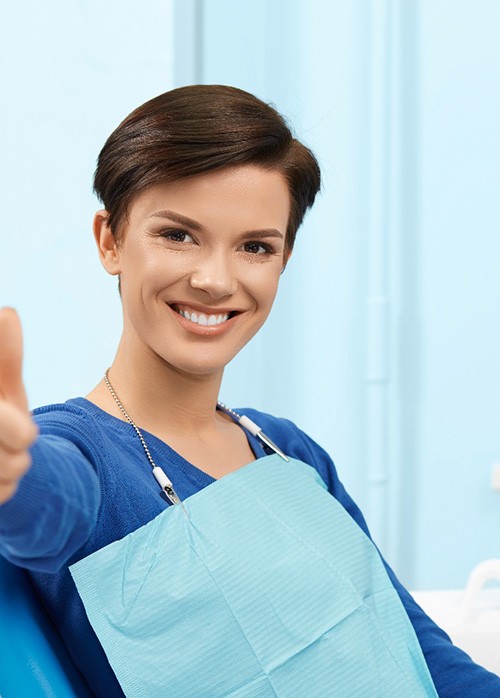 Happy dental patient making thumbs up gesture