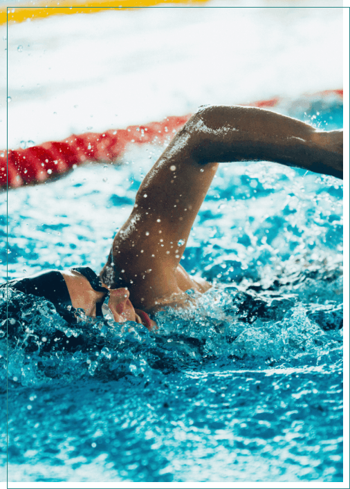 Person swimming while wearing goggles and swim cap