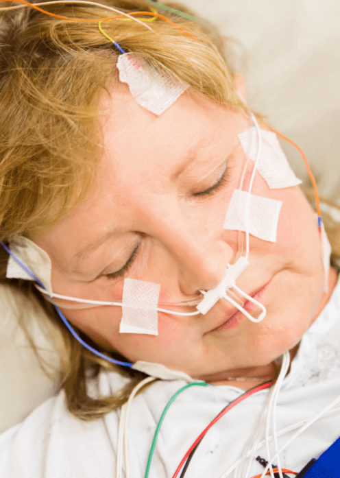 Sleeping woman wearing electrodes to test for sleep apnea