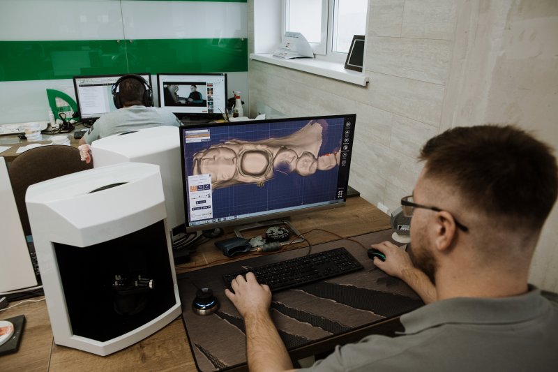 A lab worker using CAD/CAM technology in dentistry